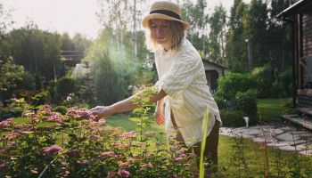 una donna si prende cura del giardino in primavera sapendo quali fiori e piante piantare